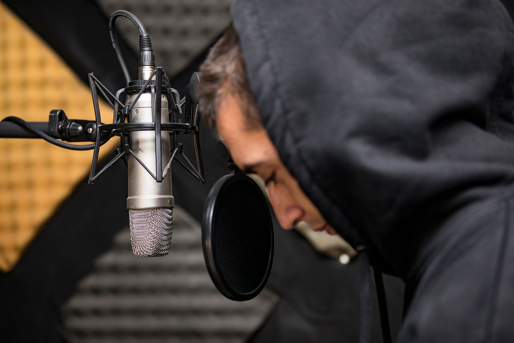 Artist standing in front of a studio microphone
